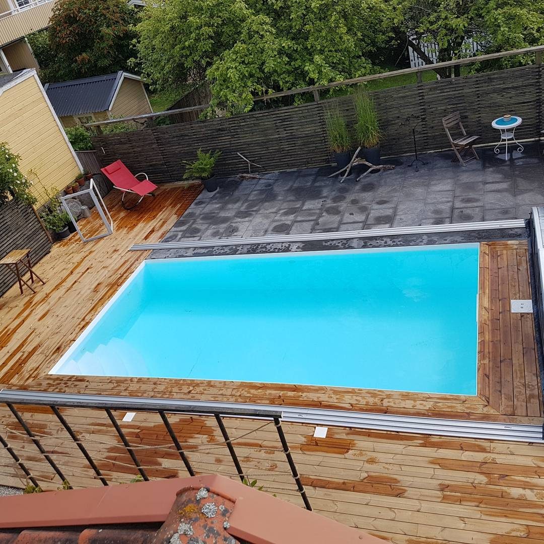 Pool med trädäck i villaträdgård